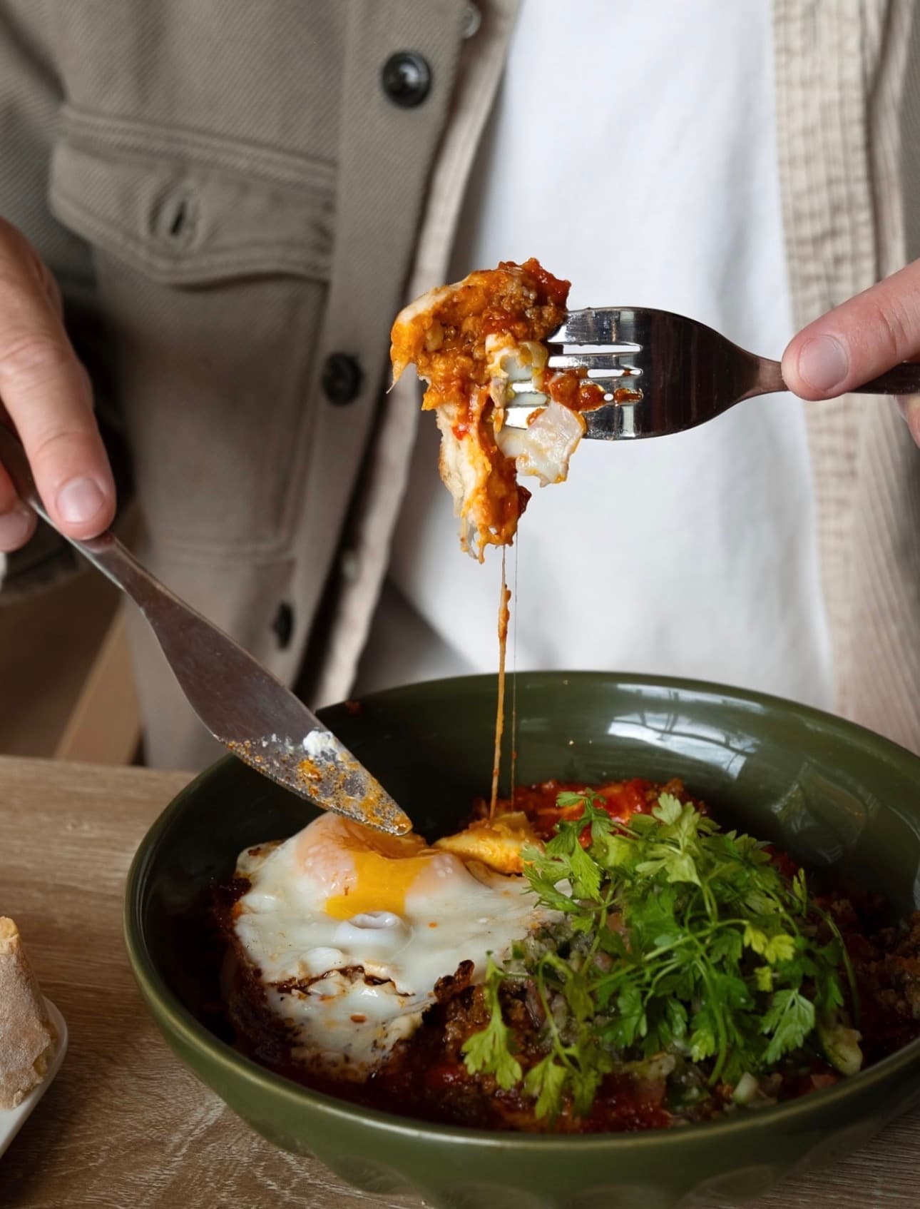Plat mijoté aux œufs, tomates et coriandre servi dans un bol